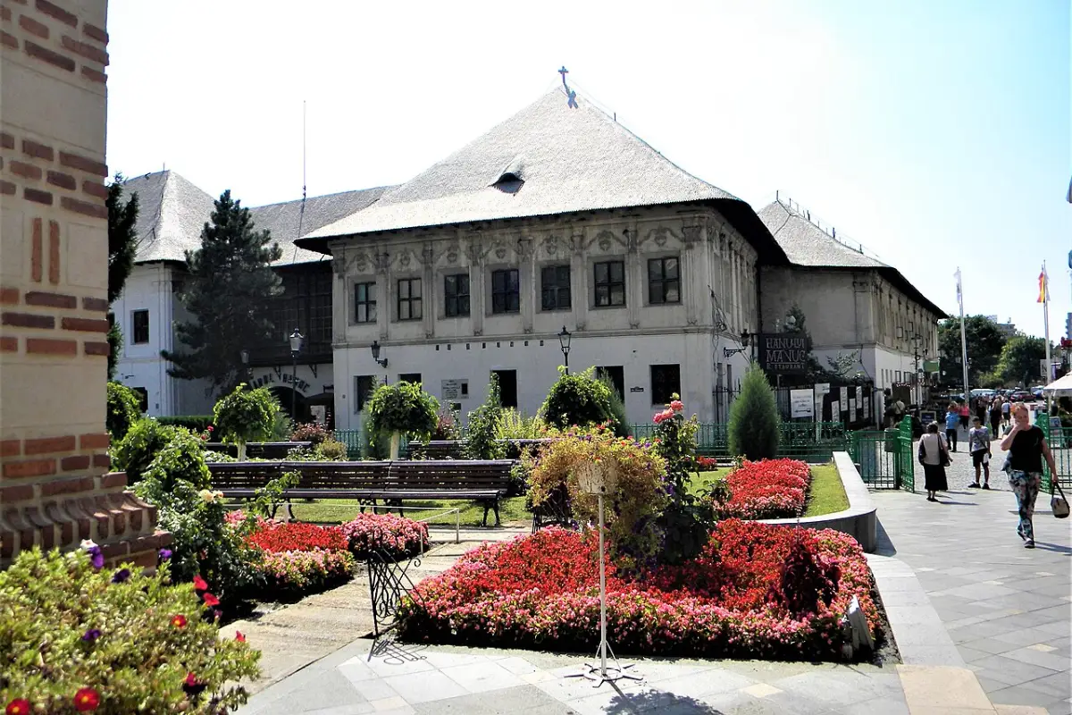 Hanul lui Manuc văzut din exterior, cu ronduri de flori în față, în Centrul Vechi, Sectorul 3 din București